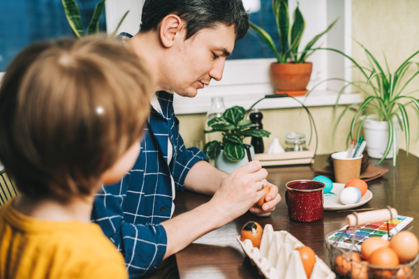 A father and son paint Easter eggs together